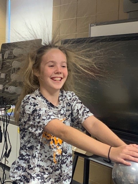 Girl using Van de Graaff Generator